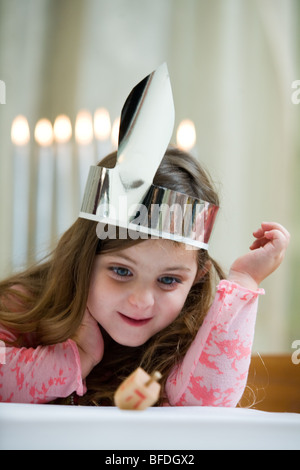 Girl playing with a dreidel. Stock Photo