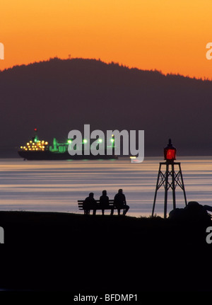 Silhouette of people on bench viewing sunset, Burrard Inlet, Vancouver, British Columbia, Canada Stock Photo