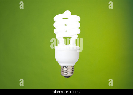 a compact fluorescent light bulb against a green background Stock Photo