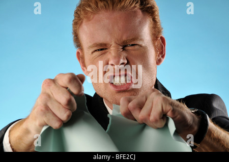 Angry man in suit tearing up papers Stock Photo