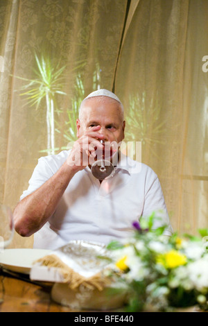 Elder man drinking blessed wine at Seder Night. Stock Photo