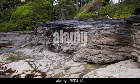 Beachcombers rest in a natural beach cave along the Juan de Fuca Marine Trail on Vancouver Island, British Columbia, Canada Stock Photo