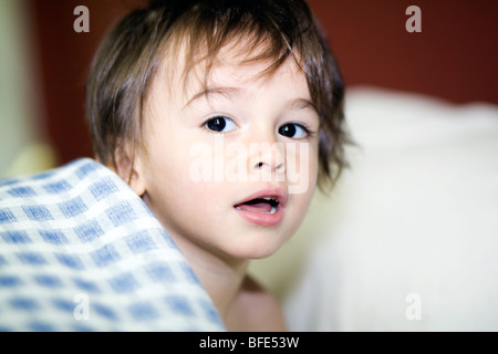 2 1/2 year old boy playing in bed sheets, Montreal, Quebec, Canada Stock Photo