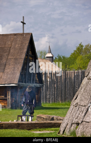 Costumed character tending a fire in the Sainte-Marie Among the Hurons settlement in the town of Midland, Ontario, Canada Stock Photo