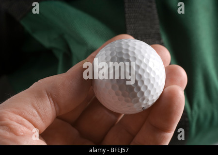 A man's hand holding a golf ball Stock Photo