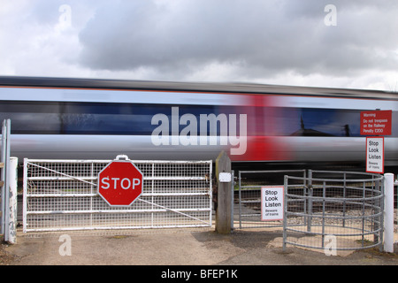Train passing manned gated level crossing, Worcestershire, England UK Stock Photo