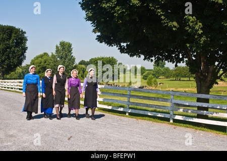 Young amish women friends walking down country lane road in Lancaster PA.   housewives Stock Photo