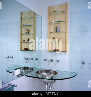 Glass shelving above stainless steel fitted units in modern kitchen ...