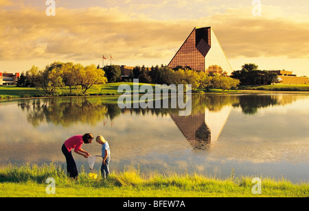 Two girls view water creatures collected from a pond in front of the Royal Canadian Mint, Winnipeg, Manitoba, Canada Stock Photo