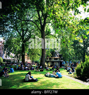 People relaxing, the half-timbered Tudor foly gardener's shed 1925 in the distance, Soho square, London, Great Britain, UK, GB Stock Photo