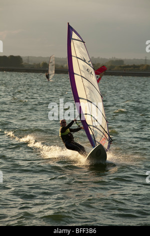 Windsurfers at sunset on Farmoor Reservoir, Oxfordshire, Uk Stock Photo