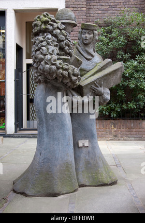 Situated in Pont Street London are these two stone sculptures of ladies and their wares in deep conversation. Stock Photo