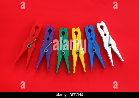 Multicolor laundry clips on red background Stock Photo