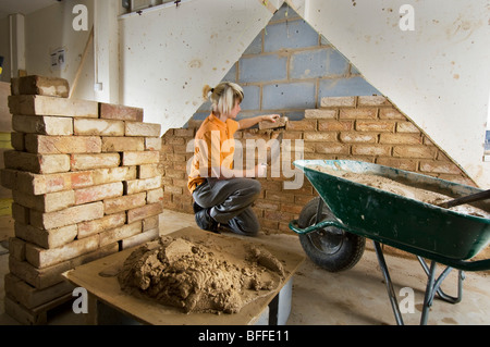 Girl student learning practical bricklaying  at a City College