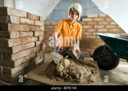 Girl student learning practical bricklaying  at a City College