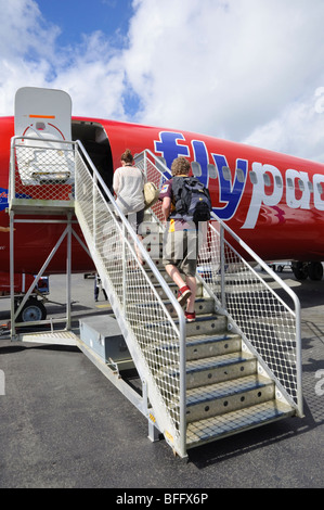 Passengers board a flight home from their holiday in the tropics. Click for details. Stock Photo