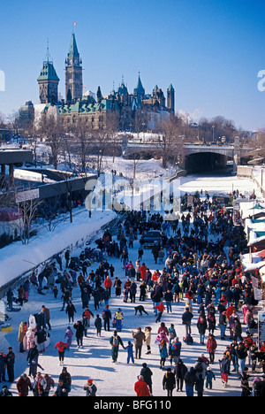 Skaters on Rideau Canal during Winterlude, Parliament Buildings in the background, Ottawa, Ontario, Canada Stock Photo