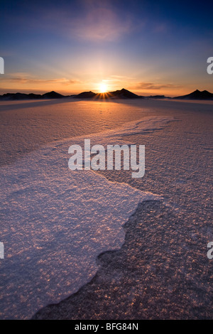 The sun sets behind mountains of pack ice on Lake Huron in Bayfield, Ontario, Canada Stock Photo