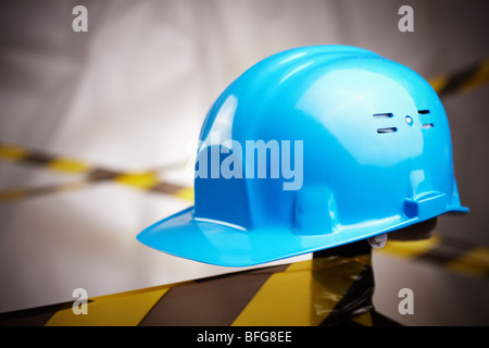 blue helmet and protective tape on site, selective focus on center Stock Photo