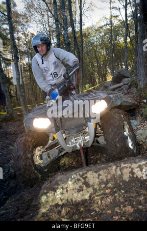 Man rides all-terrain vehicle (ATV) on rocky terrain in woods. Trial off-road biking. Sweden. Stock Photo