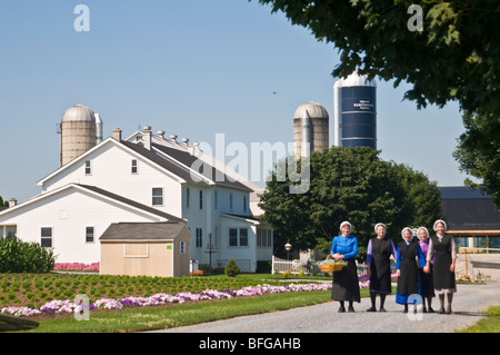 Young amish women friends walking down country lane road in Lancaster PA.   housewives Stock Photo