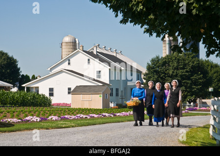 Young amish women friends walking down country lane road in Lancaster PA.   housewives Stock Photo