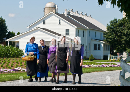 Young amish women friends walking down country lane road in Lancaster PA.   housewives Stock Photo