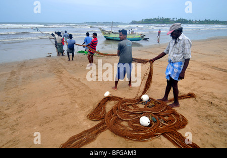 Fishermen pull in  their nets on a beach near Galle, Sri Lanka Stock Photo