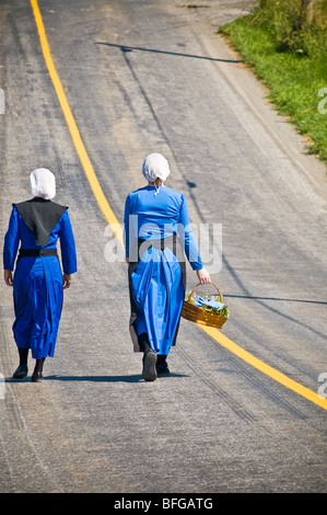 Young amish women friends walking down country lane road in Lancaster PA.   housewives Stock Photo