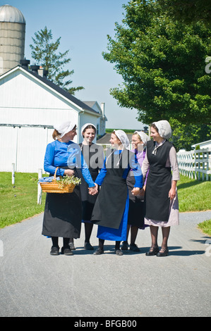 Young amish women friends walking down country lane road in Lancaster PA.   housewives Stock Photo