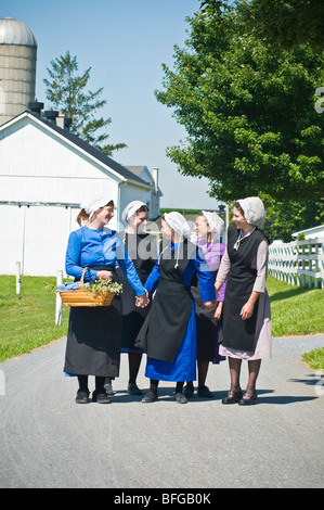 Young amish women friends walking down country lane road in Lancaster PA.   housewives Stock Photo