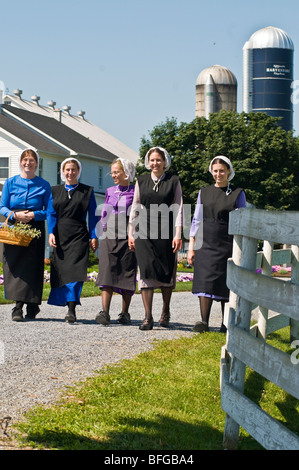 Young amish women friends walking down country lane road in Lancaster PA.   housewives Stock Photo