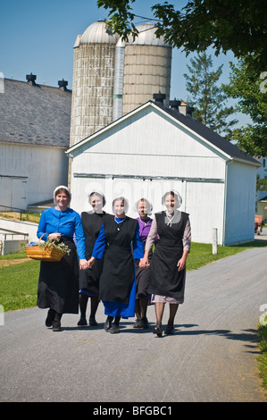 Young amish women friends walking down country lane road in Lancaster PA.   housewives Stock Photo