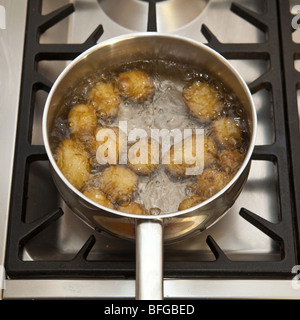 Pan of potato's boiling on a gas stove hob. Stock Photo