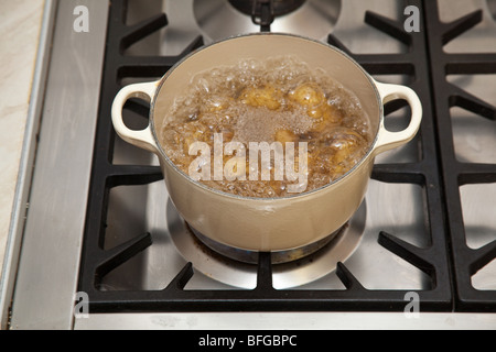 Pan of potato's boiling on a gas stove hob. Stock Photo