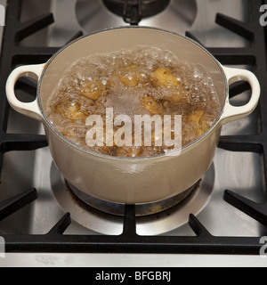 Pan of potato's boiling on a gas stove hob. Stock Photo