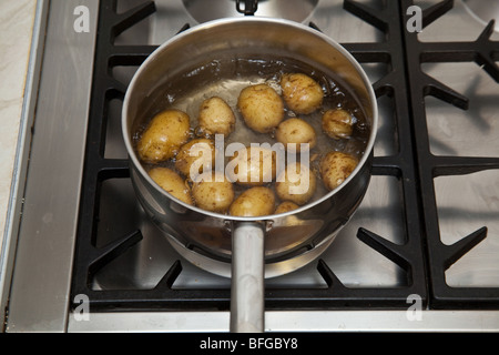 Pan of potato's boiling on a gas stove hob. Stock Photo