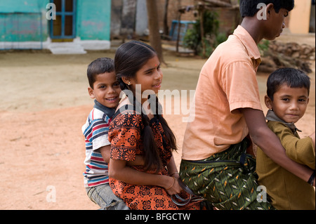 Indian teenager and children riding a bicycle in a rural Indian village. Andhra Pradesh, India Stock Photo