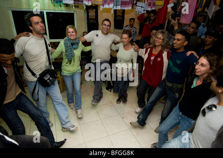 A spontaneous party involving locals and tourists in a roadside café Stock Photo