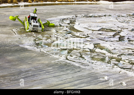 An Amphibex machine breaking up ice on the Red River, Selkirk, Manitoba, Canada Stock Photo