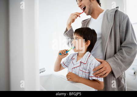 Father and Son Brushing Teeth in bathroom Stock Photo