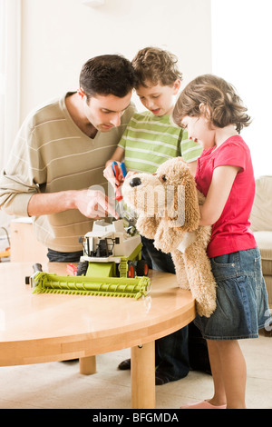 father fixing toy with son Stock Photo