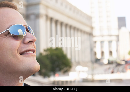 Man wearing sunglasses, smiling, outdoors Stock Photo