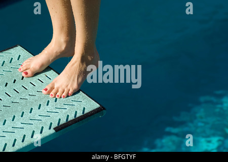 Female swimmer standing on diving board Stock Photo