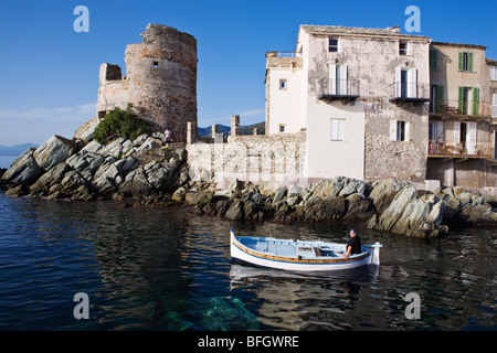 Man in boat leaving Erbalunga harbour Corsica France Stock Photo