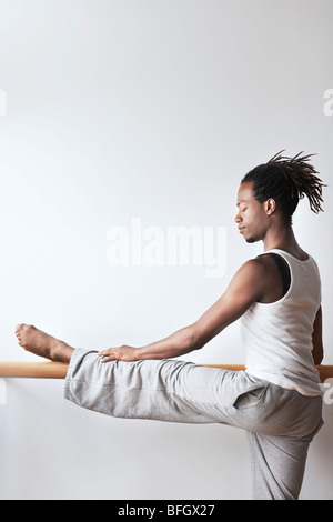 Ballet Dancer stretching at bar Stock Photo