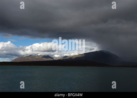 Storm-cell or stormy weather over Summit Lake with blue sky in background near Paxson, Alaska. Stock Photo