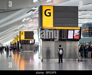 Man checking check in information screen Heathrow international airport London England UK Stock Photo