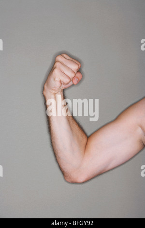 Man flexing biceps, close-up on arm Stock Photo