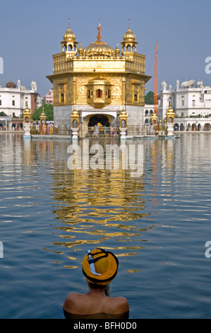 Sikh pilgrim bathing in the sacred pool (Amrit Sarovar). The Golden Temple. Amritsar. Punjab. India Stock Photo